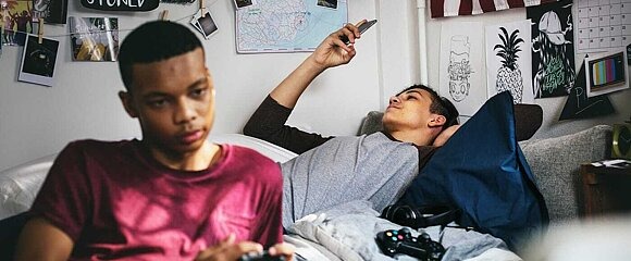 Junge mit Smartphone und Junge mit Controller