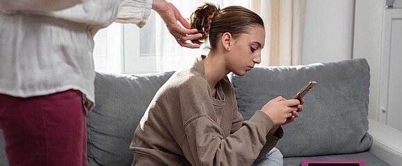 Mädchen mit Smartphone und Tablet auf dem Sofa