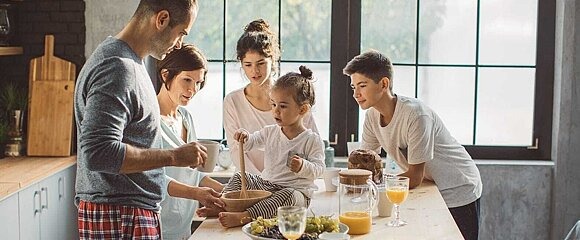 Eine Familie beschäftigt sich um einen Tisch