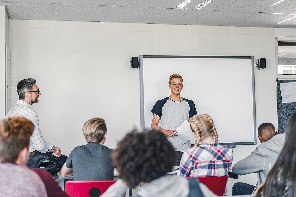 Jugendlicher hält einen Vortrag vor seiner Klasse.