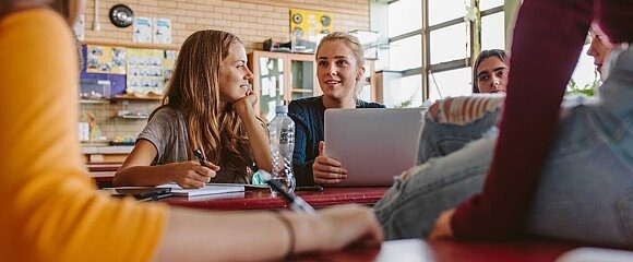 Jugendlichen im Klassenraum mit Laptop